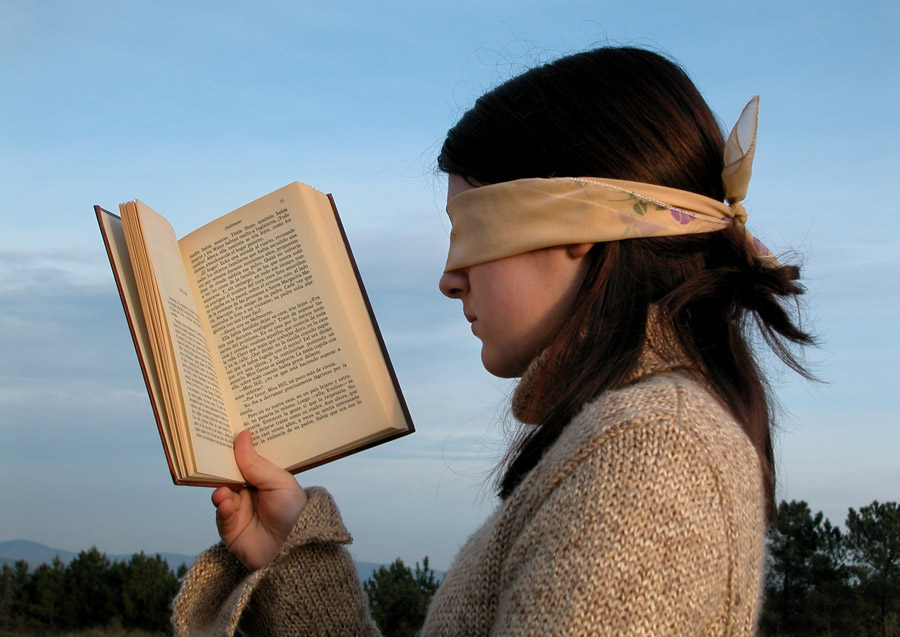 目隠しで本を読む女性